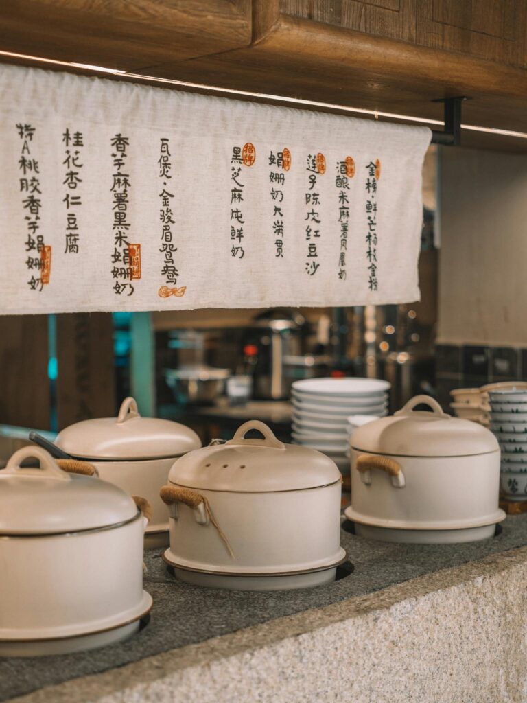 A cozy Asian kitchen scene featuring ceramic pots and menu in calligraphy.
