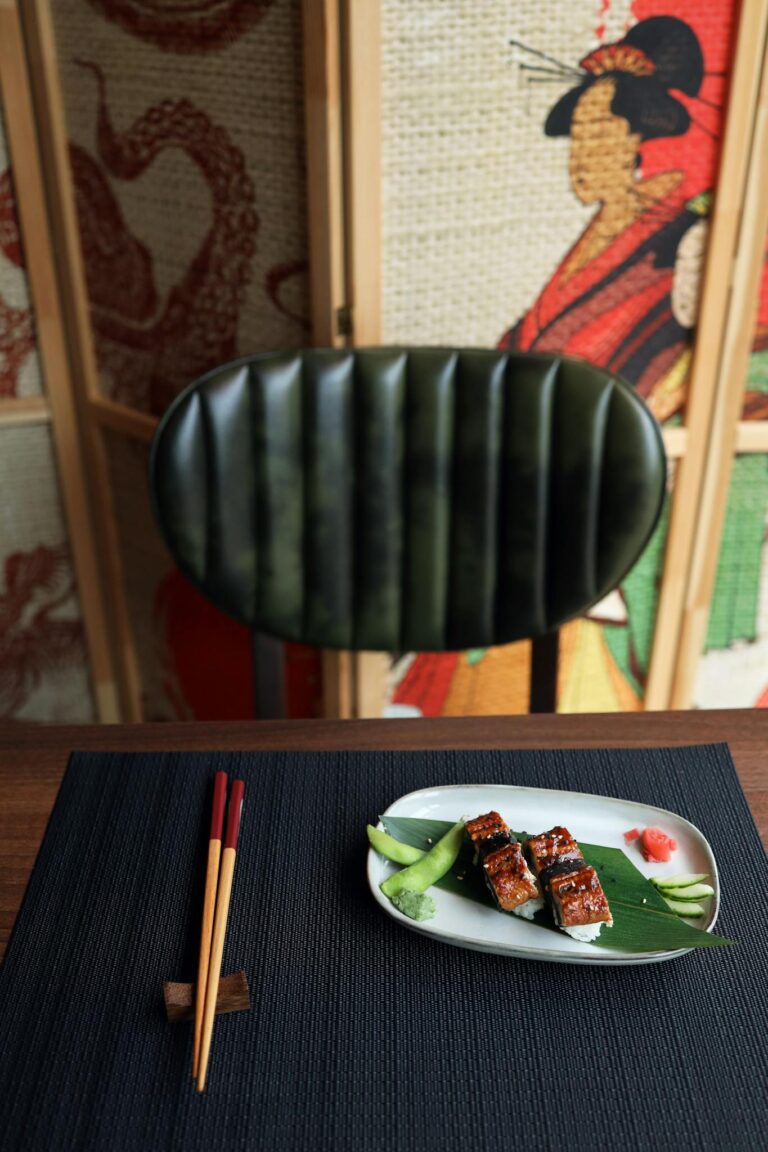 Japanese dish with artistic backdrop, showcasing traditional decor and chopsticks.